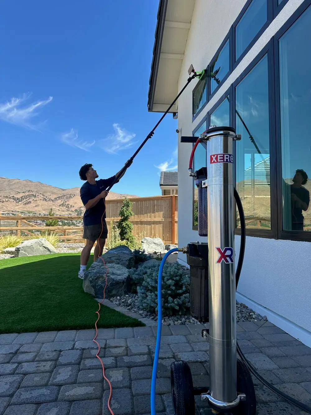 Willow Lane technician using a water-fed pole to clean second-story windows